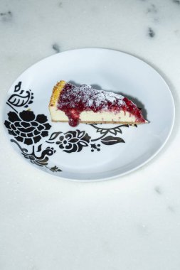Üzerinde dut reçeli olan güzel bir dilim cheesecake..