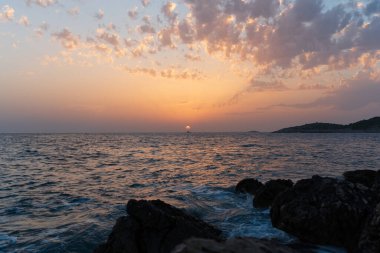 Denizde gün batımı, deniz kıyısında yaz akşamı, güneş ufukta batıyor.