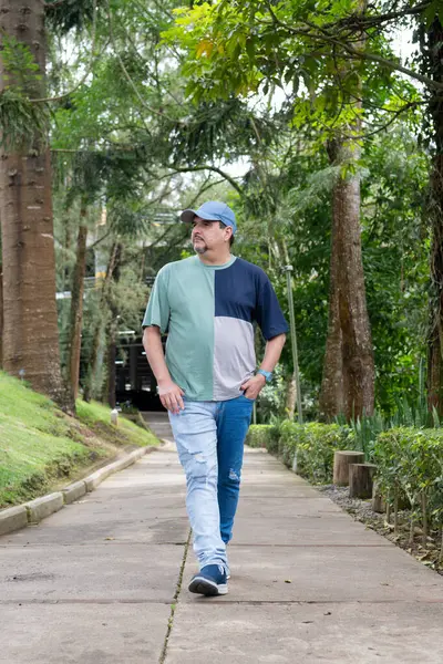 Genç adam parkta gündelik giyiniyor.