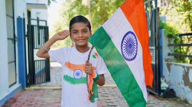 Aile bireyleri olan çocuklar üzerinde Hint bayrağı logosu olan tişörtler tasarlıyor ve tutuyor, arka planda yeşillikle birlikte el sallıyor ya da koşuyor, Bağımsızlık ya da Cumhuriyet Günü 'nü kutluyorlar.