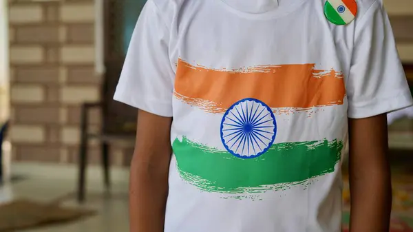 Stock image kids with family members wearing Indian flag logo design t shirt and holding, waving or running with Tricolour with greenery in the background, celebrating Independence or Republic day