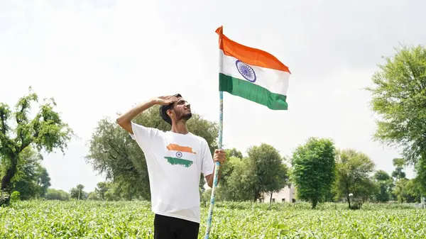 Stock image kids with family members wearing Indian flag logo design t shirt and holding, waving or running with Tricolour with greenery in the background, celebrating Independence or Republic day