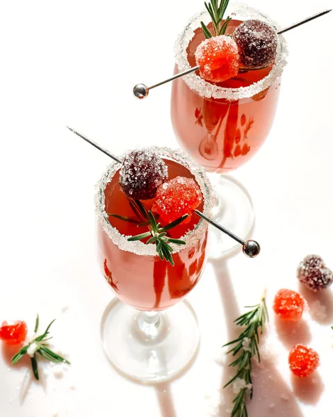 Christmas mimosa punch or cranberry margarita cocktail with cranberry juice, orange liqueur and champagne. Delicious icy drink for christmas holiday.