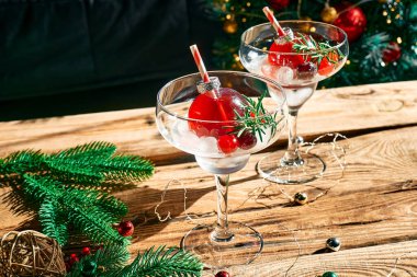 Noel içeceği mimoza, punç ya da noel süslerinde servis edilen yabanmersinli margarita kokteyli ve martini bardakları. Noel ve kış tatili partisi için lezzetli buzlu içecek fikri.