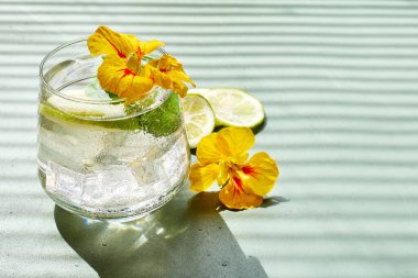 Yenilebilir nasturtiyum çiçekleri, limon ve nane yapraklı buzlu limonata. Tazeleyici yaz içeceği. Sağlıklı organik yaz gazozu. Detoks suyu. Diyet alkolsüz kuyruk kuyruğu.