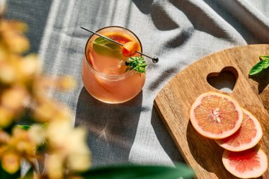 Yaz ferahlatıcı greyfurt içeceği ya da greyfurt dilimleri, buz ve bitkilerle alkollü kokteyl. Citrus detoks içeceği.