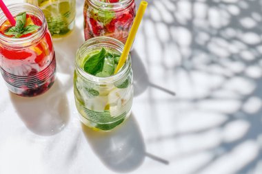 Detoks içeceği. Limon, böğürtlen ve otlarla doldurulmuş farklı türde su. Ev yapımı yaz kokteyli. Taze, sağlıklı soğuk içecek..