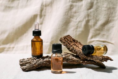 Doğal lavanta yağı ve lavanta çiçekli, ahşap kabuklu damlacık şişesi ürününüzü sunmak için keten kumaş üzerinde podyum görevi görüyor. Aromaterapi, alternatif tıp ve parfüm konsepti