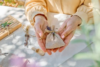 Lavanta kesesi yapan bir kadın. Giysileri gardıroba koymak için küçük bir çanta. Sıfır atık arama hediyesi. Ev yapımı aromaterapi.