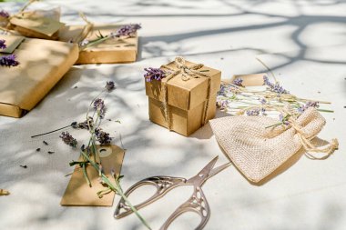 El yapımı el yapımı, geri dönüştürülmüş kağıt ve masa örtülü kurutulmuş lavanta çiçekleri içeren bir hediye paketi. Doğal estetik..