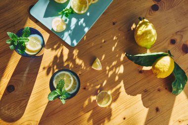 Tahta masada nane, buz ve limon dilimleri ile ferahlatıcı yaz limonata içeceği. Taze, sağlıklı, soğuk limon suyu. Limonla doldurulmuş su.
