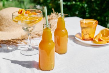 Soğuk yaz içkisi. Bahçedeki masada pipet içerek taze portakal suyunu şişelerde tazeliyorum..