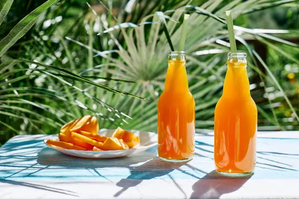 Soğuk yaz içkisi. Bahçedeki masada pipet içerek taze portakal suyunu şişelerde tazeliyorum..