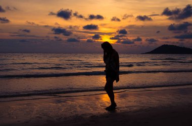 silhouette of girl sitting on beach