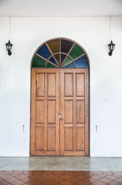 old door with lamp on wall
