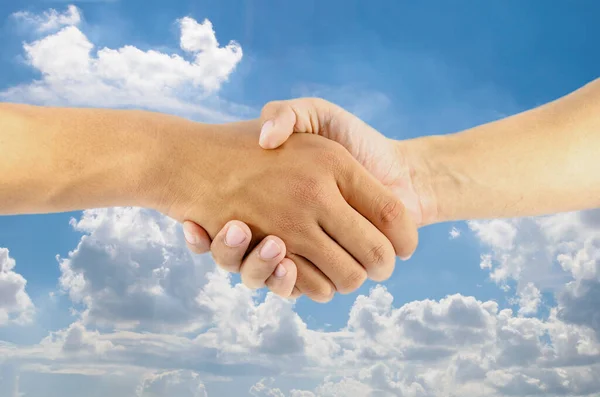 two men hand are shaking with sky background
