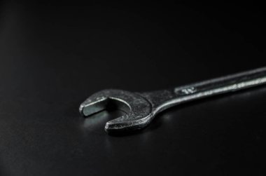 side view of silver wrench on dark light