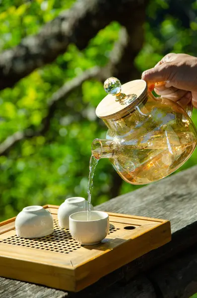 Férfi Kéz Tartja Teáskanna Öntés Tea Teáscsésze Háttér Stock Fotó