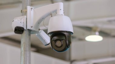 Close-up rotating black surveillance control camera indoors. Public safety concept.