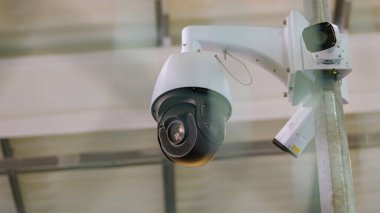 Black surveillance video camera turning to the right. Control camera rotation.