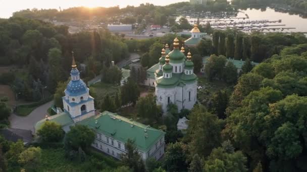 キエフの正統派教会の空中ドローンビューは木をアングします Pechersk Lavraのトップビュー 夕日の空 — ストック動画