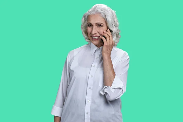 Портрет Пожилой Женщины Разговаривающей Телефону Изолированный Зеленом Фоне Пастели — стоковое фото