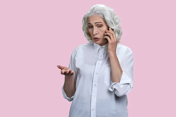 Портрет Пожилой Седой Женщины Разговаривающей Телефону Изолированный Розовом Фоне — стоковое фото