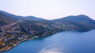 Dağların arka planındaki güzel tatil köyü manzarası. Kıyı kasabasının manzarası.