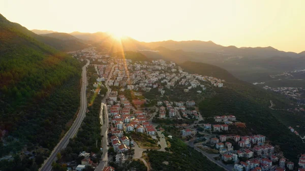 Townscape and mountains against sky during sunset. Aerial panoramic view from drone.