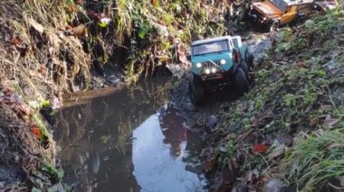 Kyiv, Ukrayna - 26.09.2021: Flatbed çekici oyuncak orman siperlerinden geçiyor. RC aracı sağanak yağmurdan sonra suda hareket ediyor.