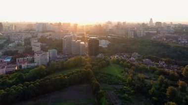 Parlak güneş ışığı olan şehir manzarası. Yukarıdan yeşil ağaçlar ve binalar.