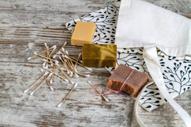 Gri tahta masada bir sürü kulak çubuğu ve sabun var. Spa için eşyalar.