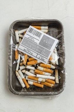 Üst manzara plastik paket kullanılmış sigara. Dikey çekim beyaz arkaplan.