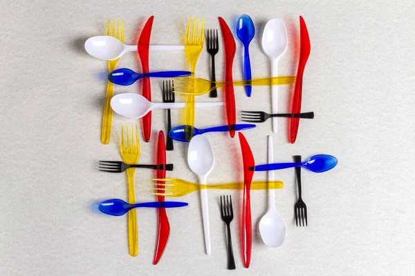 Üst Manzara Beyaz Zemin Üzerinde Renkli Plastik Kaplar Kaşıklar Bıçaklarla — Stok fotoğraf