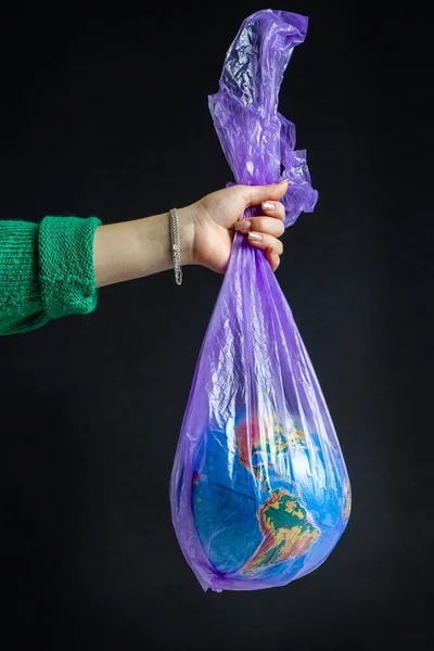 Weibliche Hand Hält Plastiktüte Mit Weltkugel Vereinzelt Auf Schwarzem Hintergrund — Stockfoto