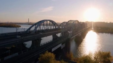 Kyiv, Ukrayna - 16.10.2019: Nehir üzerinde köprüsü olan kara pelerini ve akşam günbatımının yansıması. Araba trafiği olan otoyol.