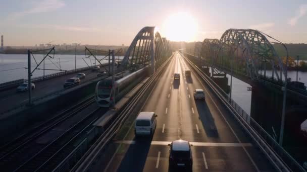橋の高速道路の空中ビュー車のトラフィック 道路に反射する明るい夜の日没の光 — ストック動画