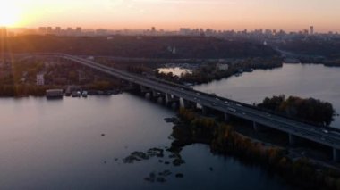 Nehir üzerinde köprüsü olan şehir manzarası. Kiev 'deki yeni Darnytskyi köprüsü. Akşam gün batımı ışığı.