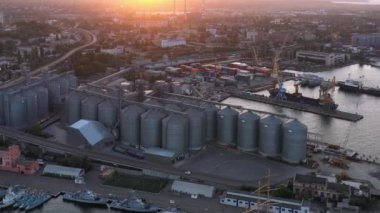 Drone view of urban city scape with sea port. Grain terminals in Odessa. Evening sunset light.