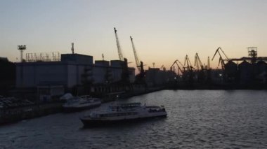 Odesa, Ukraine - 08.08.2020: Ukrainian cruise ship with moving toward a sea port. Odessa in blackout. Evening twilight sky.