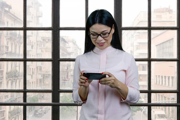 Young Asian Businesswoman Watching Video Her Smartphone Device Checkered Windows — Stok fotoğraf