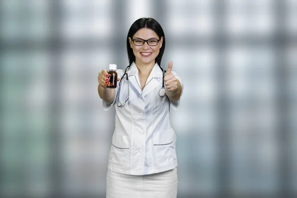 Ung Kvinnlig Läkare Visar Medicinflaska Och Ger Tummen Upp Reklam — Stockfoto