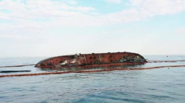 Sunken drowned tanker ship near the aground. Broken rusty ship on the shallow water.