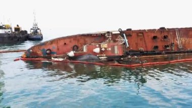 Odesa, Ukraine - 09.08.2020: Close up of broken rusty oil tanker ship in the shallow water. Sunken drowned ship after the crash.