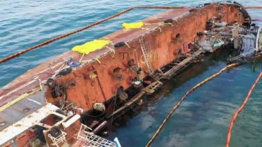 Overturned rusty oil tanker ship in Odessa sea port shallow water. Drowned ship after the wreck.