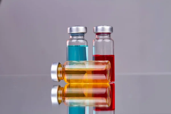 Sammlung Von Gläsernen Medikamentenflaschen Mit Farbigen Medikamenten Reflektierende Oberfläche Mit — Stockfoto
