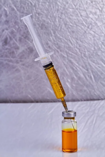 装有金光闪闪的注射器插在疫苗瓶里 垂直射击近身 — 图库照片