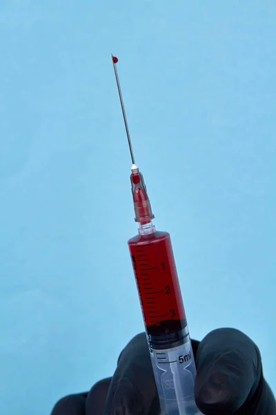 Zavřete Injekční Stříkačku Krví Jehle Svislé Modré Pozadí Záběru — Stock fotografie