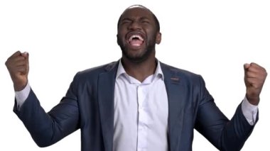 Takım elbiseli neşeli, başarılı Afrikalı işadamı başarıya seviniyor. Ağır çekim. Beyaz izole arkaplan.