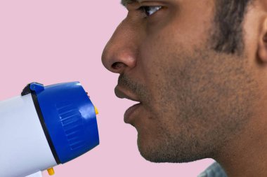 Güneyli megafonlu adamın yüzünü kapatın. Pembe arka planda izole edilmiş.